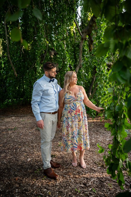 Wayne and Christy walking beside an ivy-covered wall