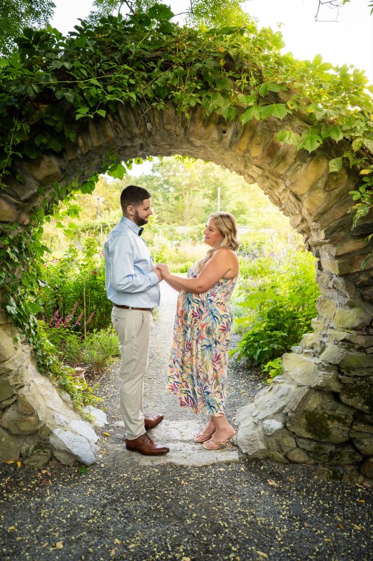 Wayne and Christy facing one another beneath a stone arch