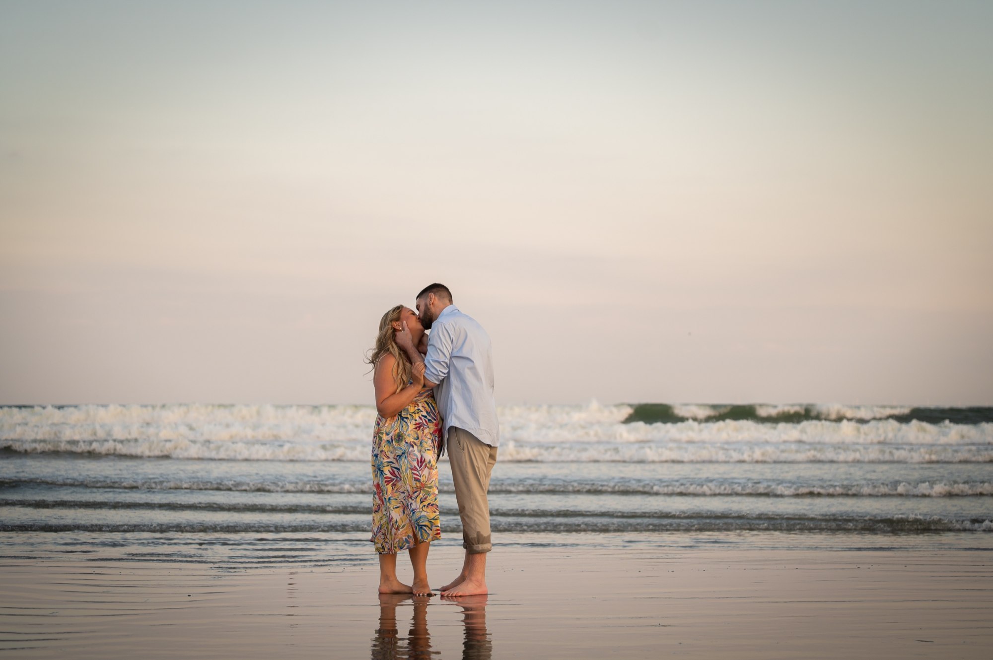 Wayne and Christy sharing a kiss by the waves