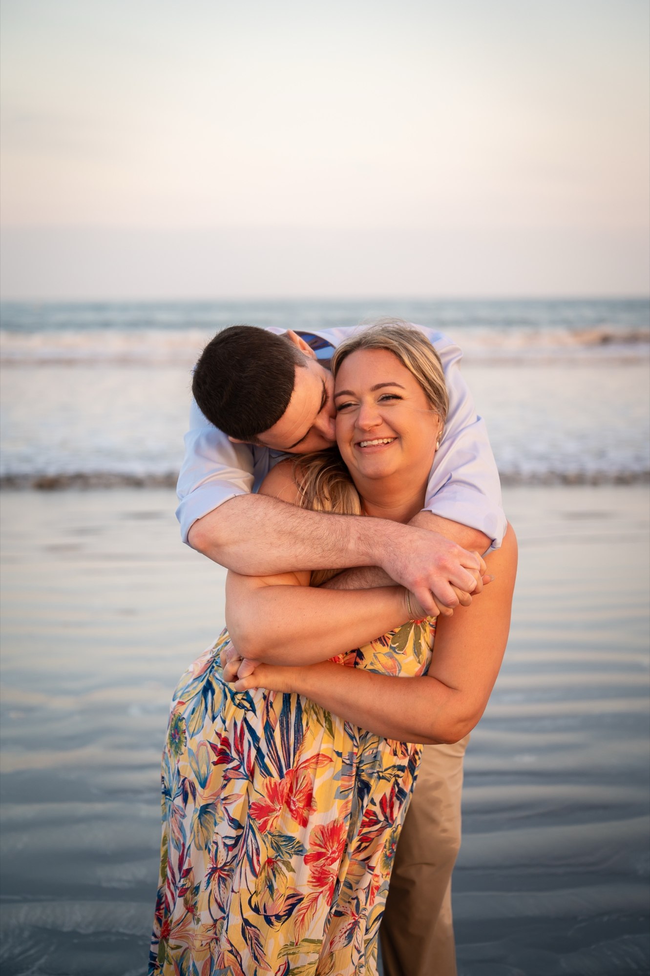 Wayne and Christy laughing together by the ocean